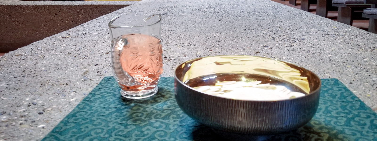 Picture of crystal picture with wine in it next to bowl with communion bread in it.