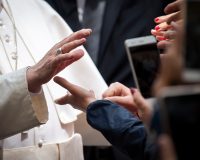 Picture of Pope Francis' hand extended greeting audience.